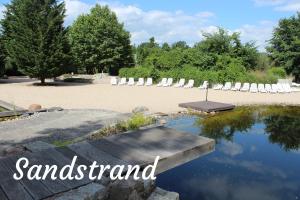 a bunch of lawn chairs and a pool of water at Ferienwohnungen Margaretenhof am Plauer See in Brandenburg an der Havel