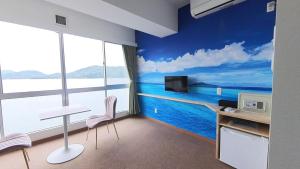 a room with a wall mural of the ocean at 森口屋アートスクエア in Shodoshima