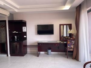 a room with a desk and a television on the wall at Hotel Thiên Hồng in Phú Quốc