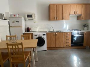 a kitchen with wooden cabinets and a table and a dishwasher at ANTIC ESTANC in Campanet
