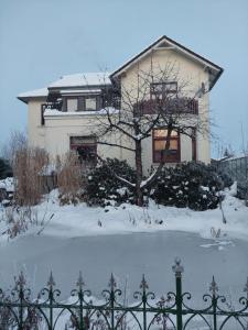 a house in the snow in front of a fence at Monteurzimmer bei der Gärtnerei in Grünendeich +2 photos