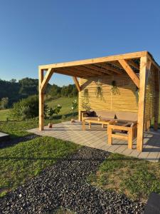 a wooden pergola with a bench on a patio at Harmony Cottage - Private Jacuzzi & Nature in Banja Luka