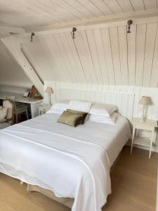 a large white bed in a room with two tables at La Luna Guesthouse in Bruges