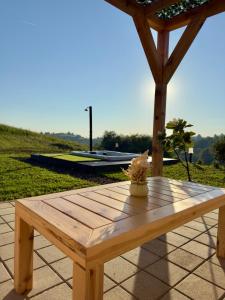 a wooden picnic table on a patio with a roof at Harmony Cottage - Private Jacuzzi & Nature in Banja Luka +7 photos