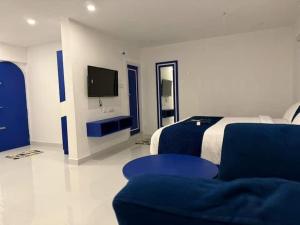 a bedroom with a bed and a tv and a couch at CASA Lasa Beach view in Kālapettai