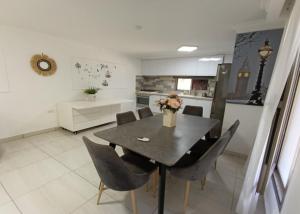 a dining room with a table and chairs in a kitchen at קסם הרימון - 4 צימרים מושלמים עם בריכה וג'קוזי in ‘Azriqam +33 photos