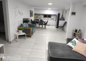 a living room with a couch and a dining room at קסם הרימון - 4 צימרים מושלמים עם בריכה וג'קוזי in ‘Azriqam