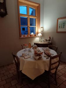 a dining room table with a white table cloth on it at LE JARDIN DU ROSSIGNOL in Willeman