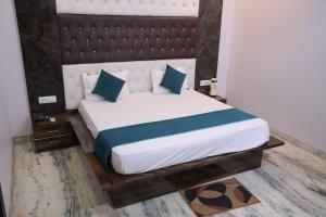 a bedroom with a large white bed with blue pillows at HOTEL chandra garden in Govardhan