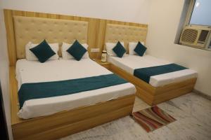 two beds in a small room with sidx sidx sidx sidx at HOTEL chandra garden in Govardhan +5 photos
