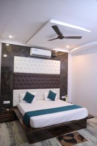 a bedroom with a large bed and a ceiling fan at HOTEL chandra garden in Govardhan