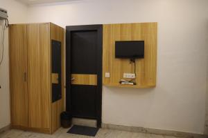 a room with a door and a tv on a wall at HOTEL chandra garden in Govardhan