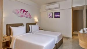 a hotel room with a white bed in a room at Regenta Z Vadodara in Vadodara