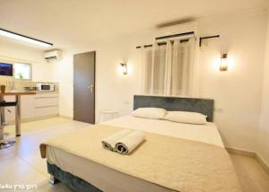 a bedroom with a large bed with towels on it at קסם הרימון - 4 צימרים מושלמים עם בריכה וג'קוזי in ‘Azriqam