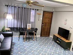a living room with a couch and a table and a television at Udon House in Udon Thani