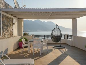 a patio with a table and chairs on a balcony at Ostria View in Kardamaina