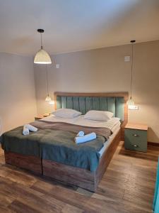 a bedroom with a large bed with two towels on it at Hotel-restaurant Stumari in Ushguli