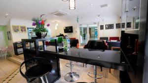 a salon with a black counter with chairs and flowers at Jubilee Hotel in Bandar Seri Begawan