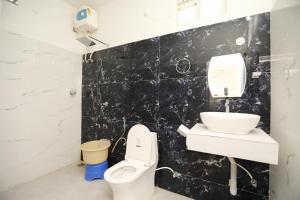a bathroom with a toilet and a sink at CASA Lasa Beach view in Kālapettai