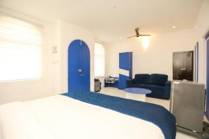 a bedroom with a bed and a blue door at CASA Lasa Beach view in Kālapettai