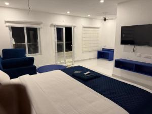 a bedroom with a large bed and a tv at CASA Lasa Beach view in Kālapettai +15 photos