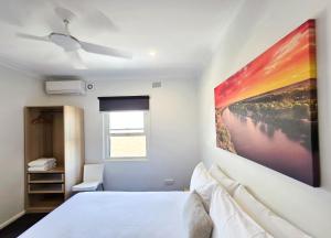 a bedroom with a large painting on the wall at Plantation Hotel Coffs Harbour in Coffs Harbour