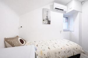 a white bedroom with a bed and a window at Le Trilou - By BEST KEYS - Triplex Totalement Climatisé 3 Chambres - Lit King Size - Smart TV Canal Plus & Amazon Prime - Cuisine Équipée - Télétravail - Proche Centre & Canal de Bourgogne - Check-in Autonome in Brienon-sur-Armançon