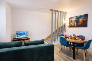 a living room with a couch and a table and a tv at Le Trilou - By BEST KEYS - Triplex Totalement Climatisé 3 Chambres - Lit King Size - Smart TV Canal Plus & Amazon Prime - Cuisine Équipée - Télétravail - Proche Centre & Canal de Bourgogne - Check-in Autonome in Brienon-sur-Armançon