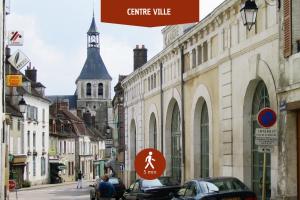 a city street with cars parked on the street at Le Trilou - By BEST KEYS - Triplex Totalement Climatisé 3 Chambres - Lit King Size - Smart TV Canal Plus & Amazon Prime - Cuisine Équipée - Télétravail - Proche Centre & Canal de Bourgogne - Check-in Autonome in Brienon-sur-Armançon