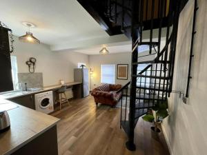 a kitchen and a living room with a spiral staircase at Central Industrial Chic 2-Bedroom Flat in Crewe +4 photos