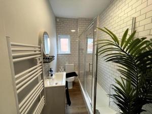 a bathroom with a sink and a shower and a toilet at Central Industrial Chic 2-Bedroom Flat in Crewe