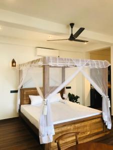 a bedroom with a bed with a canopy at La Brisa By Harry Beach Villa in Dickwella
