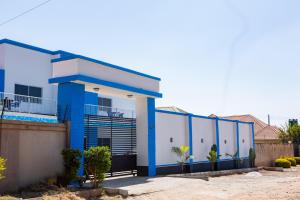 a blue and white house with a fence at Salama Blue Lodge in Lusaka