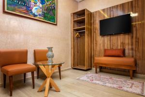 a room with two chairs and a table and a tv at Villa Hasard Marrakech in Had Abdallah Rhiat
