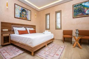 a bedroom with a large bed and a table at Villa Hasard Marrakech in Had Abdallah Rhiat +58 photos