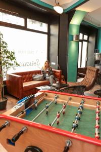 a woman sitting on a couch in a room with a pool table at Arty Paris Porte de Versailles by River in Paris