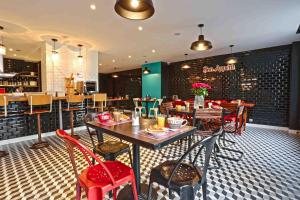 a dining room with tables and chairs in a restaurant at Arty Paris Porte de Versailles by River in Paris