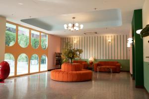 a lobby with an orange couch and chairs at The Très Hotel in Kuala Lumpur