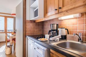 a kitchen with a sink and a counter top at Résidence Pierre & Vacances Les Temples du Soleil in Val Thorens