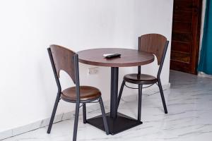 a wooden table and two chairs sitting next to a wall at Salama Blue Lodge in Lusaka