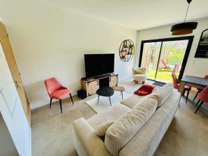a living room with a couch and a tv at Villa Corail- Piscine privée- Corsu di Core in Conca