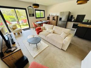 a living room with a couch and a table at Villa Corail- Piscine privée- Corsu di Core in Conca