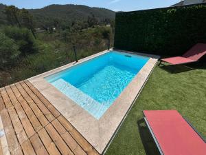 a swimming pool with a deck and a chair in a yard at Villa Corail- Piscine privée- Corsu di Core in Conca