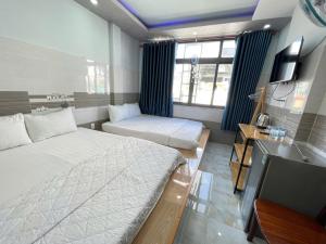 a hotel room with two beds and a television at Ong 5 Homestay Can Tho in Can Tho
