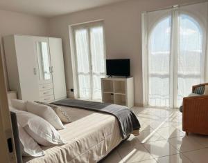 a bedroom with a large bed and a television at Casa Ilaria in Armeno
