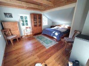 a bedroom with a bed and a wooden floor at Ferienhaus Malepartus Sächsische Schweiz in Bad Gottleuba
