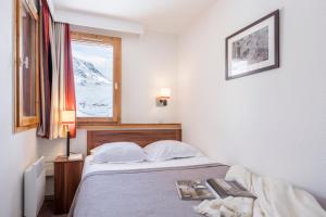a bedroom with a bed with a view of a mountain at Résidence Pierre & Vacances Les Temples du Soleil in Val Thorens