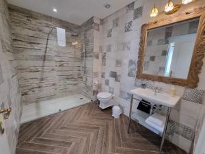 a bathroom with a toilet and a sink and a shower at Ocean View Apartments in Lourinhã