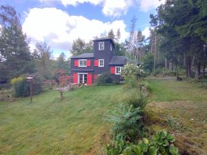 a red house on a hill in a field at Ferienhaus Malepartus Sächsische Schweiz in Bad Gottleuba