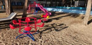 a group of playground equipment on the sand near a pool at Eco Lanta Hideaway Beach Resort in Ko Lanta